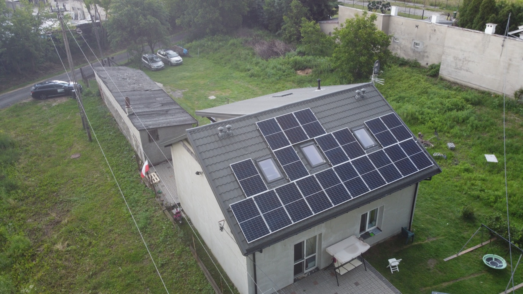Dom z instalacją fotowoltaiczną na dachu, widok z drona