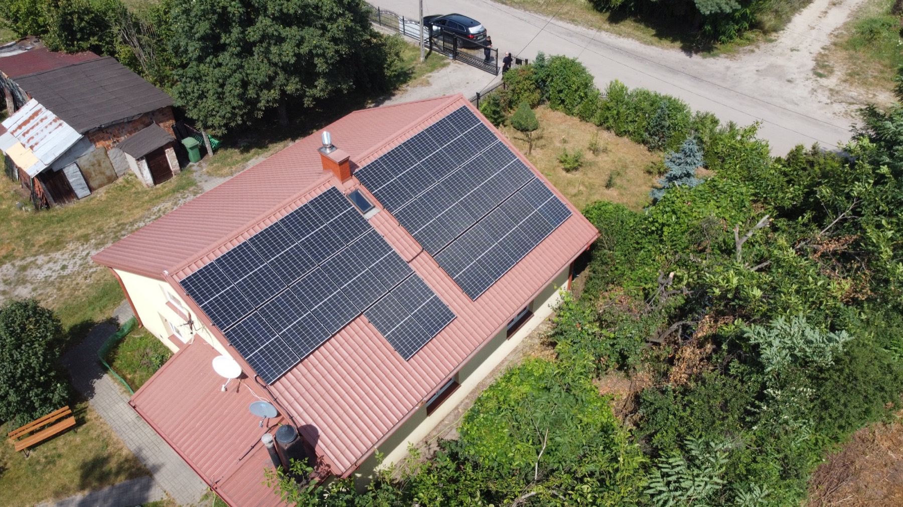 Dom z instalacją fotowoltaiczną na dachu, widok z drona