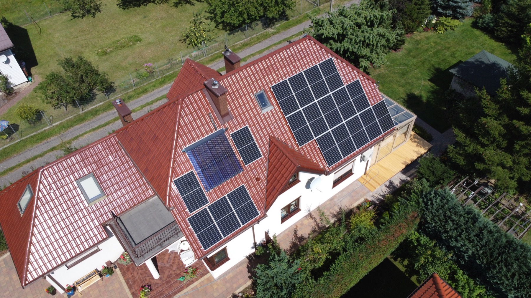 Dom z instalacją fotowoltaiczną na dachu, widok z drona