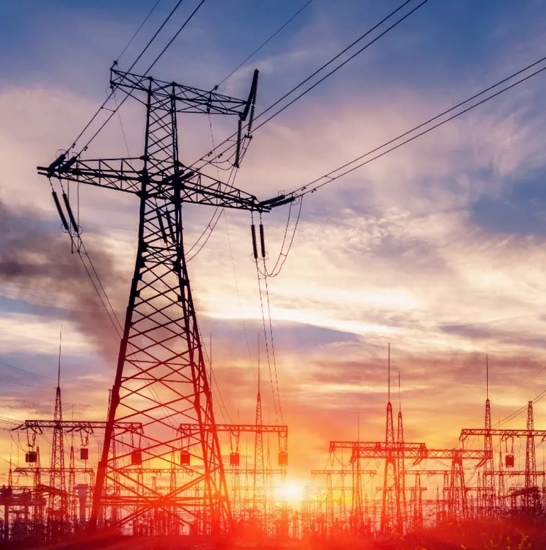 Słup energetyczny z liniami przesyłowymi na tle nieba